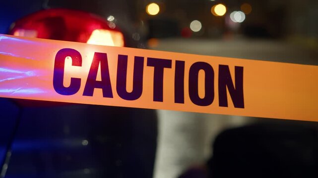 Close shot of caution tape marks accident site in rain-soaked city, vehicle remains partially visible behind barrier while investigation and road safety protocols are in effect. Details are sharp.