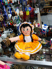 Obraz premium Colorful Traditional Doll Souvenir with Embroidered Dress at Market Stall