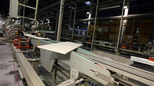 Ceramic tiles and porcelain tile factory. Ceramic tile manufacturing plant. The process of making ceramic tiles. Conveyer line for ceramic tile at plant. Close-up.