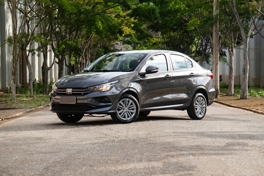 Gray Fiat Cronos front view three quarters, Compact sedan parked on tree-lined street