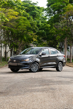 Gray Fiat Cronos front view three quarters, Compact sedan parked on tree-lined street
