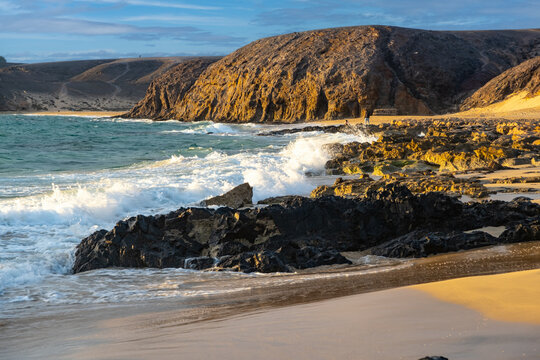 Panoramic view of Playa Papagayo's golden sands and turquoise waters surrounded by volcanic rocky cliffs on sunset - Powered by Adobe