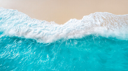 Aerial view of turquoise ocean waves gently rolling onto a pristine sandy beach