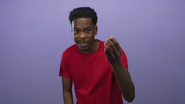 Young african american man wearing casual red t shirt beckons with fingers in studio setting; invitation.