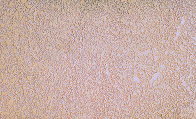 a soft pink background with a decorative plaster effect on the surface. space for text