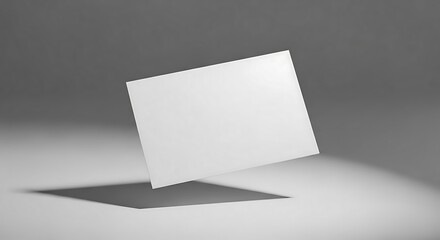 Blank white rectangular card floating in mid-air casting a shadow on a plain grey background, a conceptual product mockup