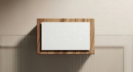 Blank white rectangle on a wooden surface with ribbed glass in the background