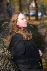 Obraz premium Portrait of a young woman in sunny autumn park
