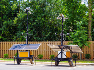 Mobile Security and Surveillance System with Solar Power and multiple cameras and floodlights. Ideal for illustrating concepts such as sustainable security systems and renewable energy infrastructure.