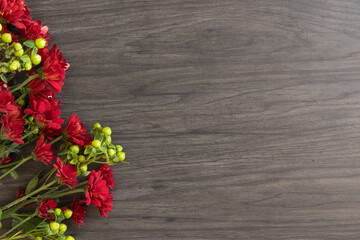 red and green flowers on a wood background with copy space