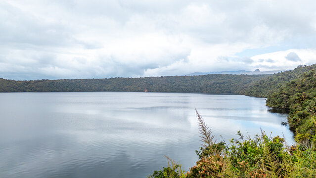 Breathtaking landscape of Ox Lagoon surrounded by lush greenery in Purace, Cauca, Colombia, perfect for nature lovers and photographers.