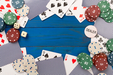 Obraz premium Poker chips and playing cards on wooden background, top view. Casino card game