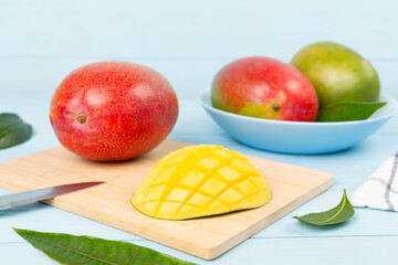 Fresh ripe mango with leaves on wooden table