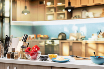 Empty kitchen prepared for cooking pizza with bowls of mozzarella and pepperoni on countertop. Baking tools, utensils and jars of spices create a homemade food setup for weekend cooking.