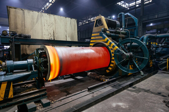 Iron pipe centrifugal pipe casting, new red hot freshly cast iron pipe at the foundry - Powered by Adobe