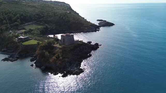 Aerial cinematic view of a Saracen tower surrounded by the blue sea in Calabria southern Italy historical landmark linked to American writer Crawford 3