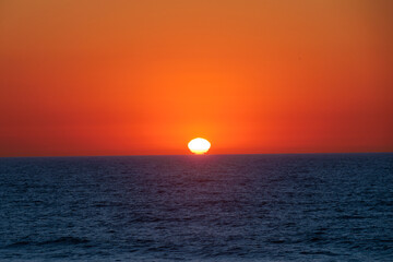 Dramatic ocean sunset with deep orange sky and calm Atlantic waves, Portugal, Ovar – Furadouro, 9 October 2025