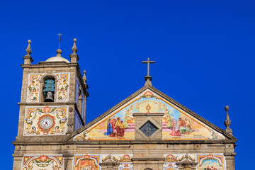 Blue tiled church facade with sun shining behind cross, Portugal, Válega, 9.10.2025