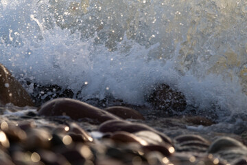 Sunrise Waves Crashing on Rocky Shore in Golden Light