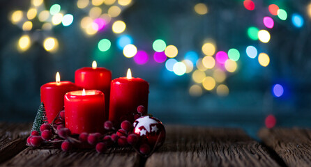 candles burning against holiday lights background