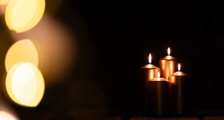 candles burning against holiday lights background