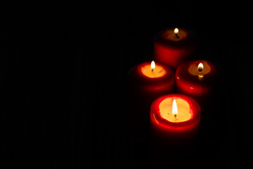candles burning against holiday lights background