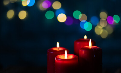 candles burning against holiday lights background