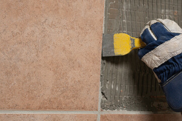 Denmark, november 2025, glove with chisel hammering tiles down