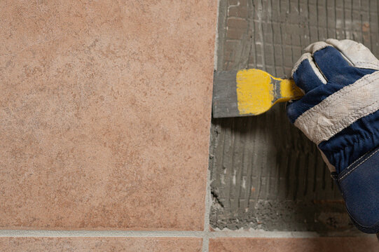 Denmark, november 2025, glove with chisel hammering tiles down