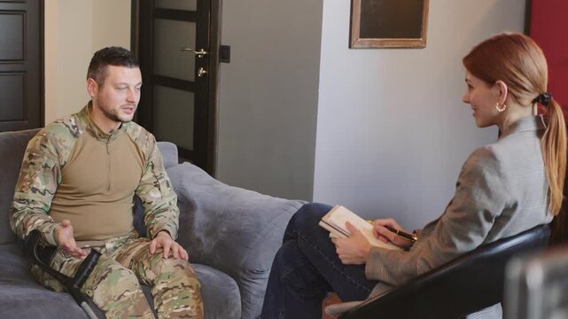 A cheerful soldier shares a funny story during a therapy session aimed at addressing mental health and anxiety issues in a supportive environment with an experienced counselor.