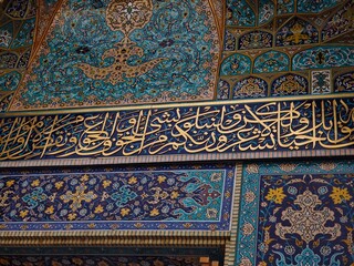Mashhad, Iran - November 15, 2025: Close-up Detail of Ornate Islamic Tilework and Gilded Thuluth Calligraphy on a Portal of the Holy Shrine.