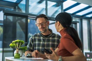 Man checking in at hotel reception asking questions