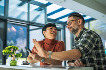Diverse couple laughing together at hotel reception check-in
