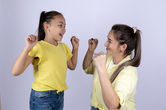 mother and daughter are smiling and raising their fists in the air