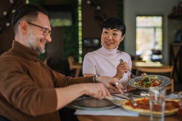 Mature multiracial couple enjoying lunch together at restaurant