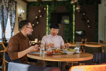 Mature multiracial couple enjoying dining experience in restaurant