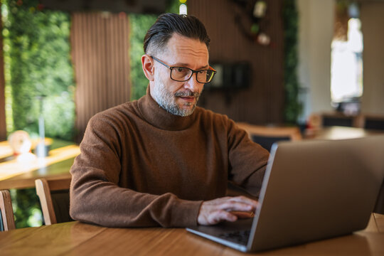 Caucasian man working on laptop in modern restaurant