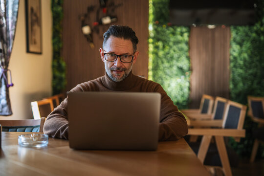 Caucasian man working on laptop in modern restaurant