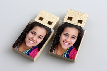 Smiling young female photo printed on two wooden USB flash drives, portable personalized data storage.