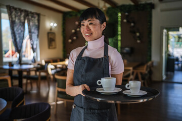 Waitress serving coffee to customers in restaurant