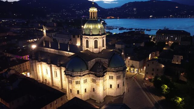 nocturnal aerial view of Como Cathedral illuminated with cinematic lights showcasing the intricate details of the dome from above