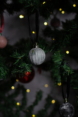 close up of Christmas ornaments on a green christmas tree, sparkly textured christmas tree baubles on artificial tree