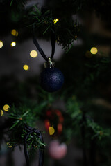 close up of Christmas ornaments on a green christmas tree, sparkly textured christmas tree baubles on artificial tree