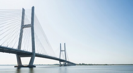 Fototapeta premium Cable-Stayed Bridge Across Waterway Under Clear Sky in Bright Sunlight