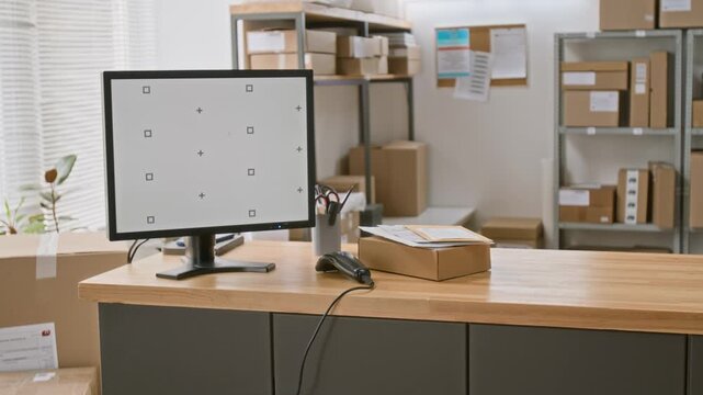Medium no people shot of desktop computer with empty white copy space screen, and barcode scanner on counter of customer service employee at courier delivery office during working hours