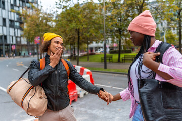 Diverse couple holding hands walking city street
