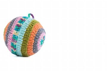 Decorative Christmas ball covered with woolen mesh forming multicolored lines on a white background.