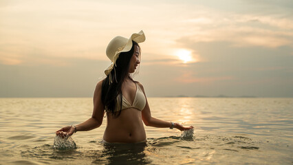 Woman enjoying water at beach during warm sunset.