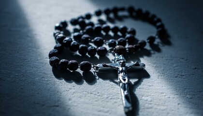 Ancient Silver Crucifix with Dark Wooden Prayer Beads Arranged on Textured Stone Surface in Dramatic Light