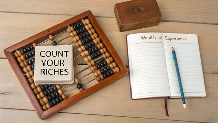 Wooden abacus count your riches and open notepad with word wealth of experience
